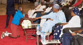 Benue school boy shakes Buhari in Aso rock on his knees (Photos)